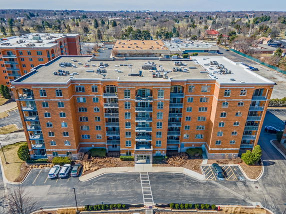 Front view of a multi-story brick apartment building with balconies.