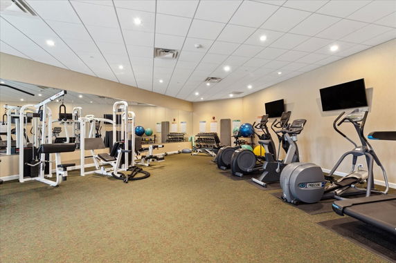 Indoor gym area with exercise equipment and mirrors.