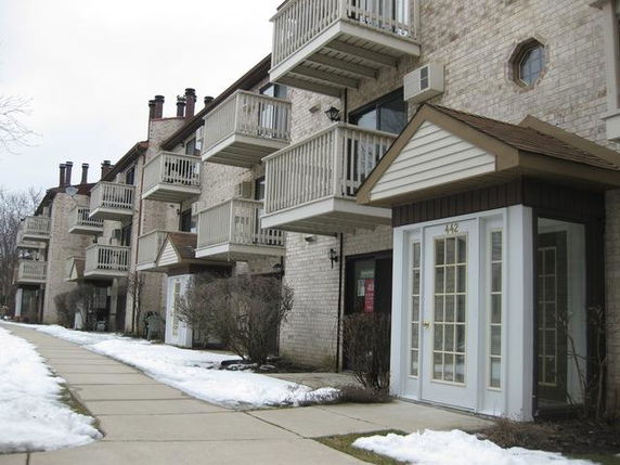 Front view of a multi-story apartment building with balconies.