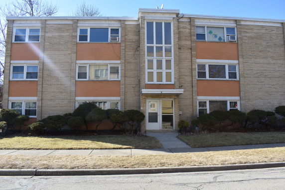 Front view of a multi-story brick apartment building.