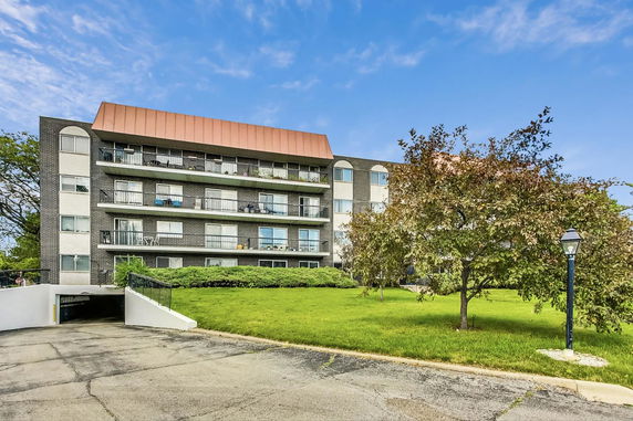 Front view of a multi-story apartment building with balconies.
