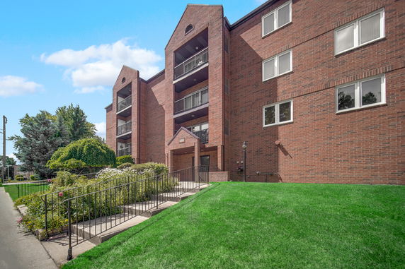 Front view of a multi-story brick building with balconies.