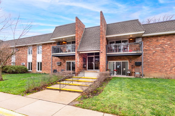 Front view of a two-story brick building with balconies and a central entrance.