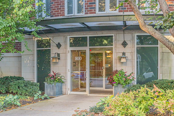 Front view of a building with a glass door entrance, brick, and stone facade.