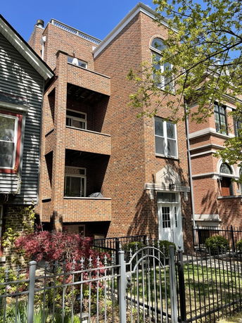 Front view of a multi-story brick building with balconies.