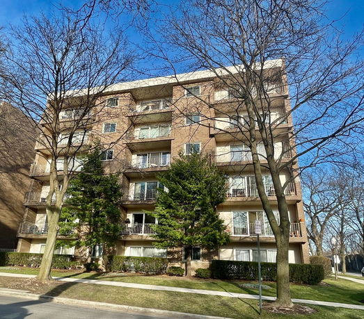 Front view of a multi-story apartment building with balconies.