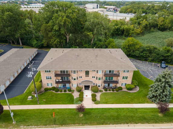 Front view of a multi-story apartment building with a brick facade and multiple balconies.