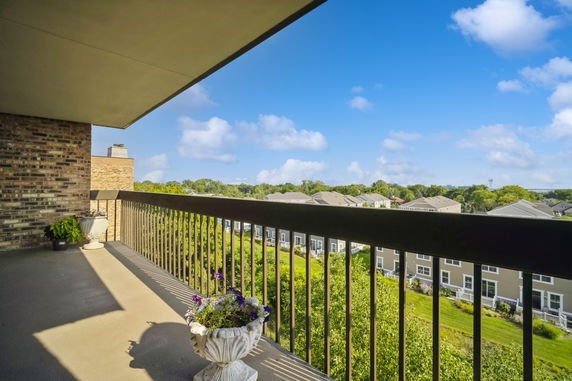 View from a balcony overlooking residential buildings and greenery.