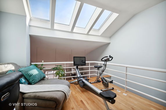 Indoor area with exercise equipment and skylights.