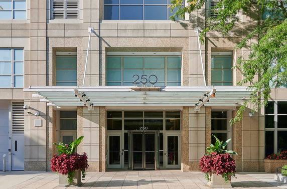 Front view of a modern building entrance with glass doors and large windows.