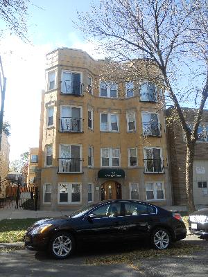 Front view of a four-story residential building with numerous windows and a central entrance.
