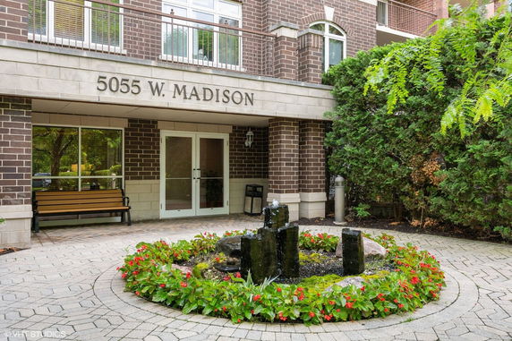 Entrance of a building with a stone facade and glass doors.