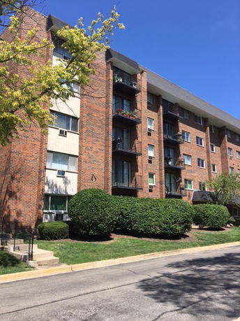 Front view of a multi-story apartment building with balconies.