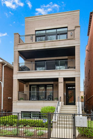 Front view of a modern three-story building with balconies.