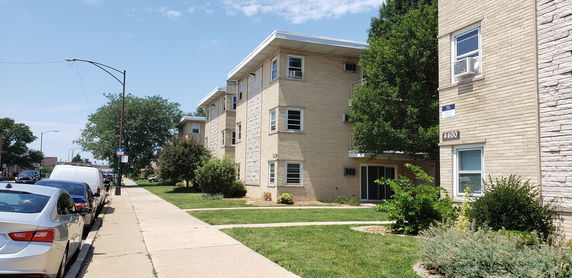 Front view of a multi-story apartment building with brick exterior.