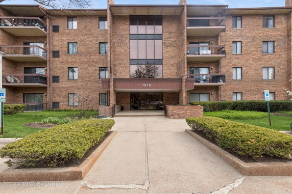 Front view of a multi-story brick building with balconies.