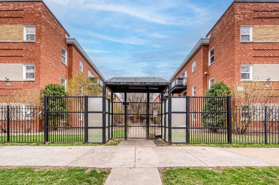 Front view of a brick building with gated entrance.