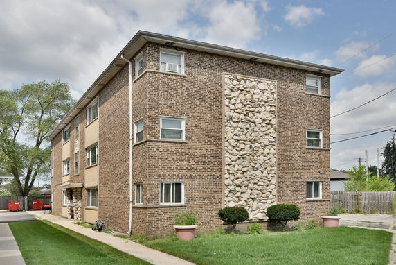 Front view of a multi-story brick building with decorative stonework.
