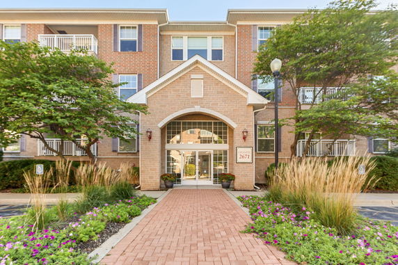 Front view of a multi-story brick building with a main entrance and balconies.