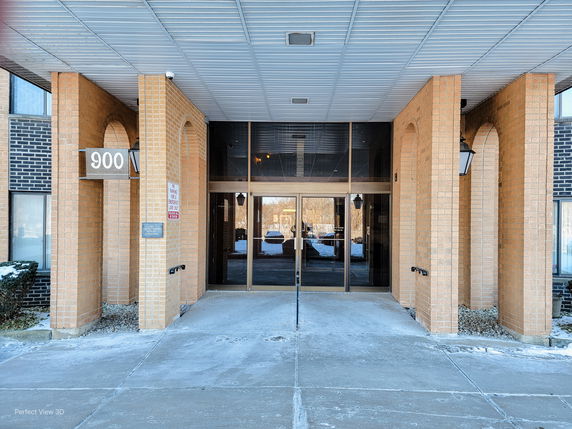 Front view of a building entrance with brick pillars and glass doors.