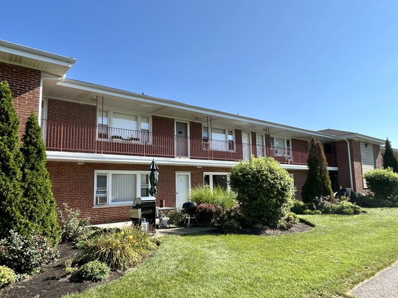 Front view of a two-story brick apartment building with balconies.