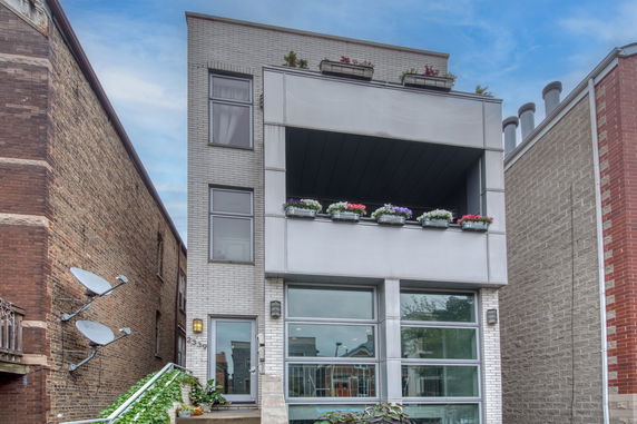 Front view of a modern multi-story building with balconies.