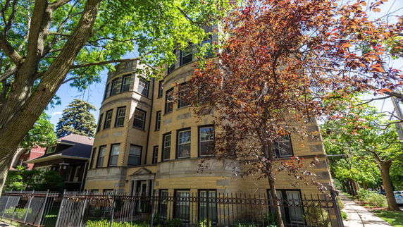 Front view of a multi-story residential building with a rounded corner facade.