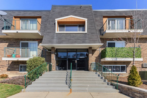 Front view of a multi-story building with balconies and a central entrance.