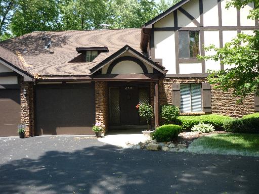 Front view of a two-story house with brick and timber facade.