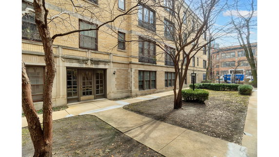Front view of a multi-story brick building with large windows and a main entrance.