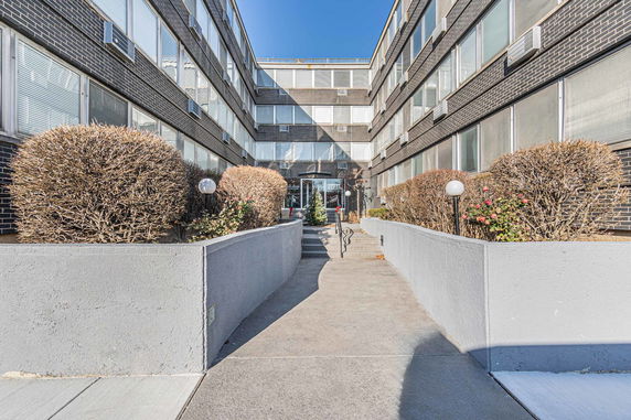 Front view of a multi-story apartment building with a central entrance.
