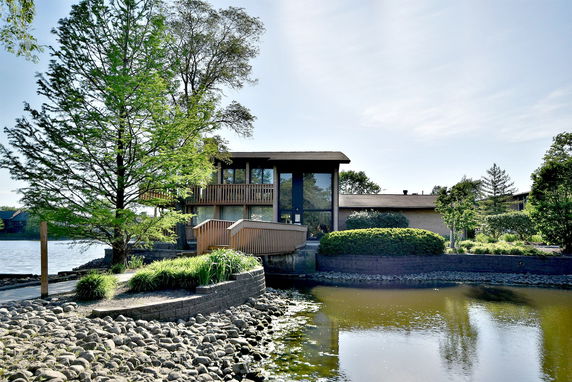 Front view of a modern two-story house with large windows and a balcony.