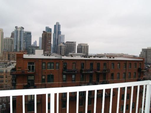 View of cityscape with multiple skyscrapers and a brown brick building in the foreground.