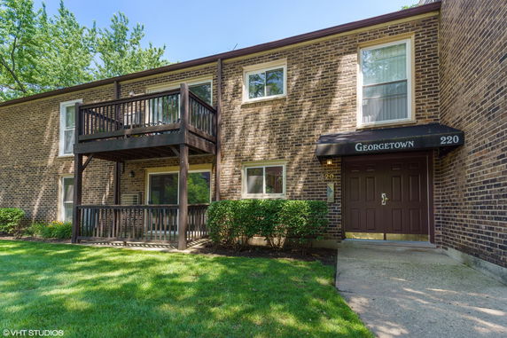 Front view of a two-story brick apartment building with balcony.