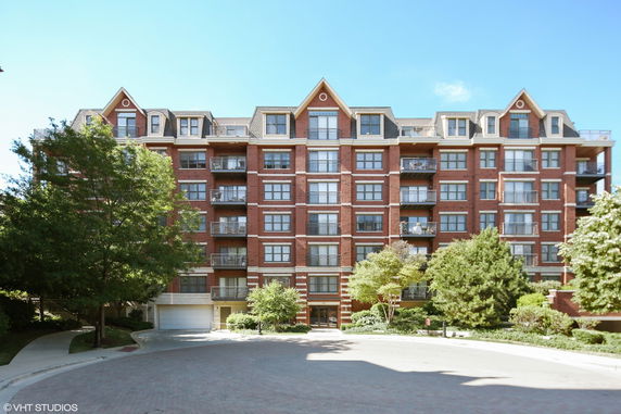 Front view of a multi-story brick residential building with balconies.