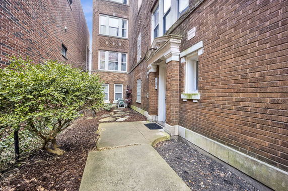 Front view of a multi-story brick building with a walkway.