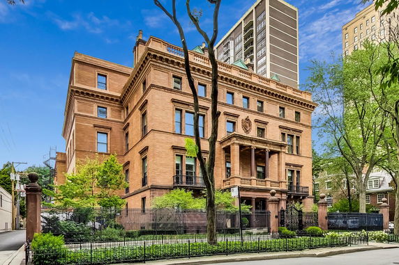 Front view of a large, historic, multi-story building with ornate architectural details.