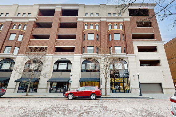 Front view of a multi-story brick building with arched windows and a main entrance labeled 'Opera Club.'