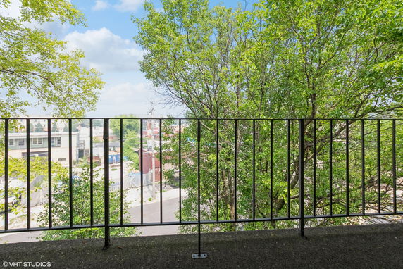 View from a balcony overlooking trees and buildings.