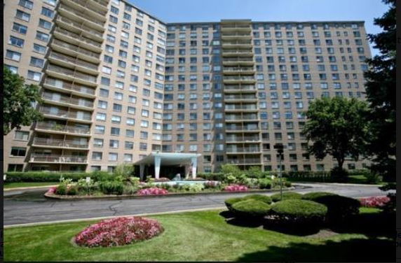 Front view of a multi-story apartment building with balconies.