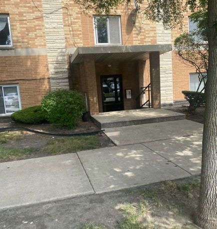 Front view of a brick building with an entrance canopy.