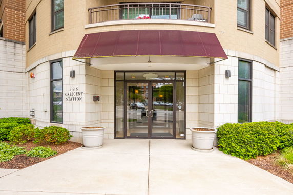 Front view of a building entrance with glass doors and an awning.