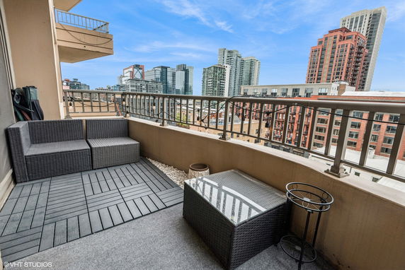 View from a balcony with city skyline and outdoor seating.
