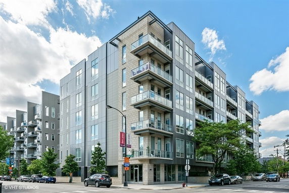 Front view of a modern multi-story apartment building with balconies.