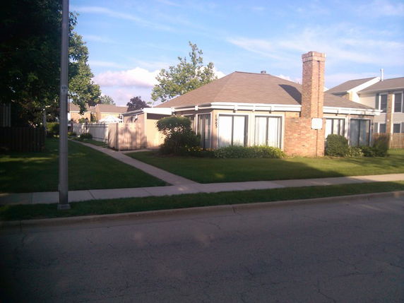 Front view of a single-story house with large windows and a chimney.