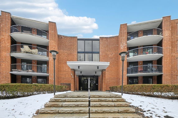 Front view of a multi-story brick building with balconies.