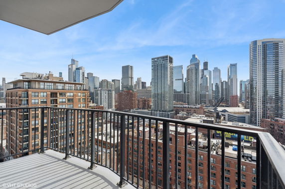 View from a balcony overlooking a city skyline with various high-rise buildings.