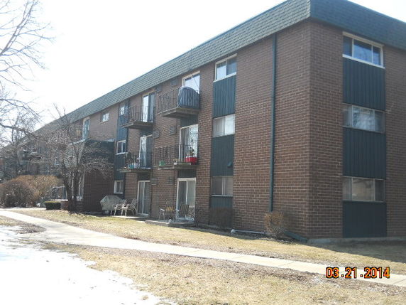 Front view of a three-story apartment building with balconies.