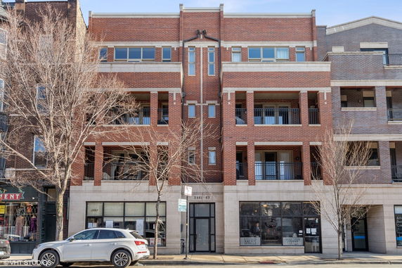 Front view of a multi-story brick building with balconies.
