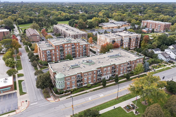 Aerial view of residential buildings with a mix of trees and roads surrounding them.